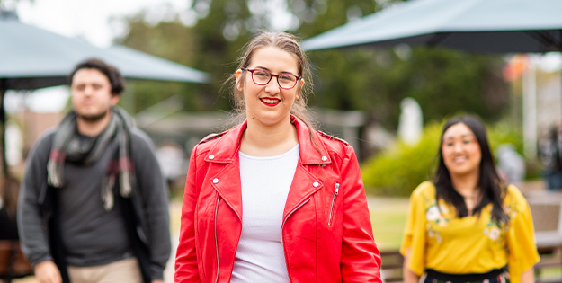 Helena walking with two friends on campus