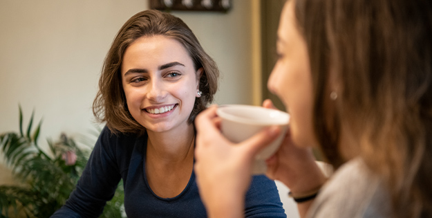 Year 12 students having coffee and smiling.