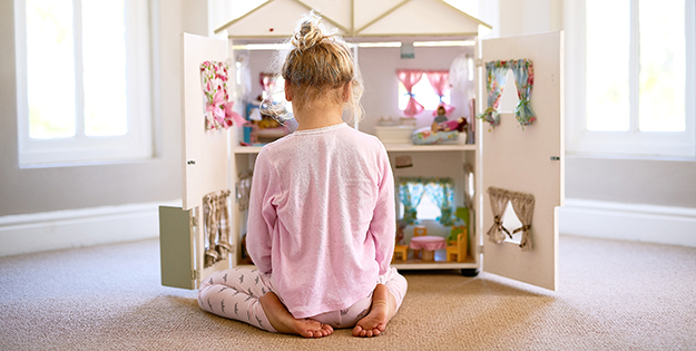 Girl plays with dollhouse