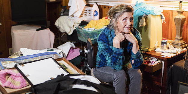 Woman in a mess filled room.