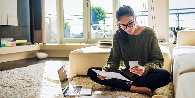 Woman studying and looking at her phone