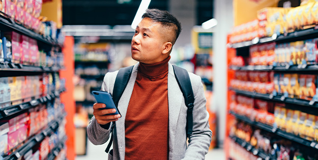 Man in grocery store with his phone
