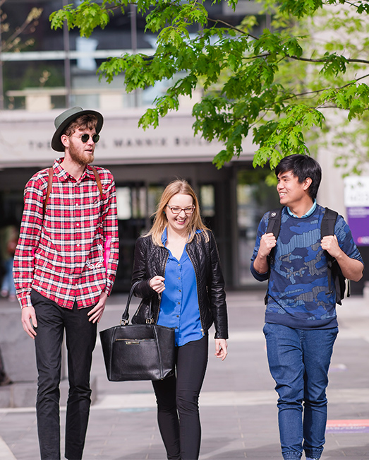 Three students walking outside ACU Melbourne Campus.