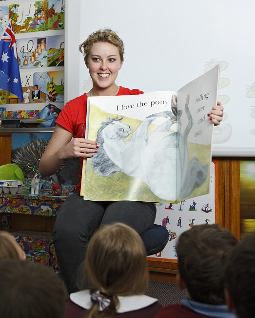Female teaching reading too class of primary school children