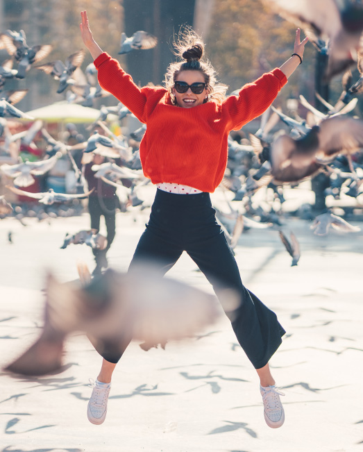 Teen leaping for joy with birds