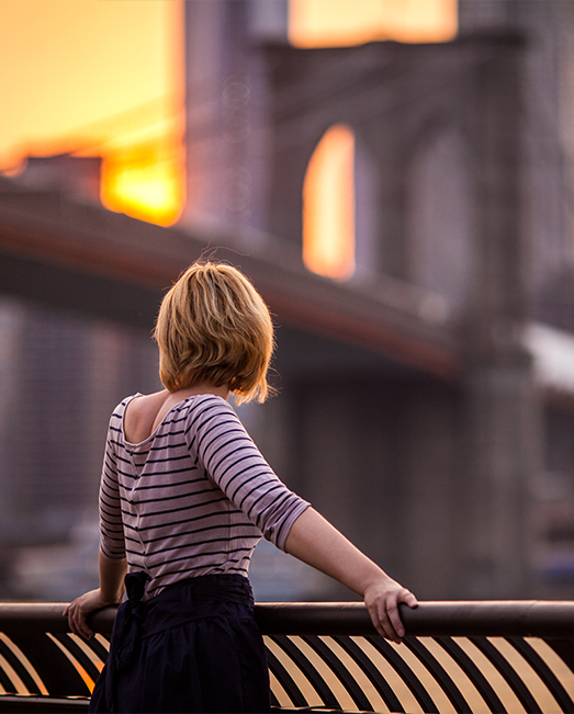 Girl watching the sunset over Brooklyn bridge