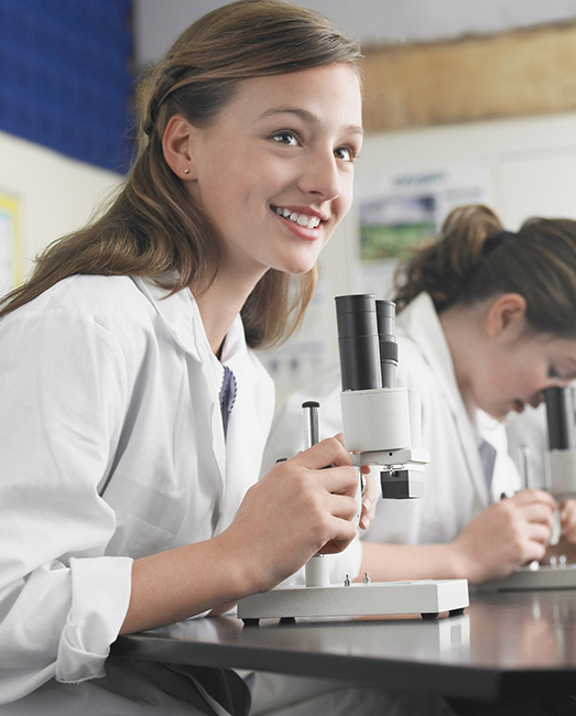 Girl looking up from microscope