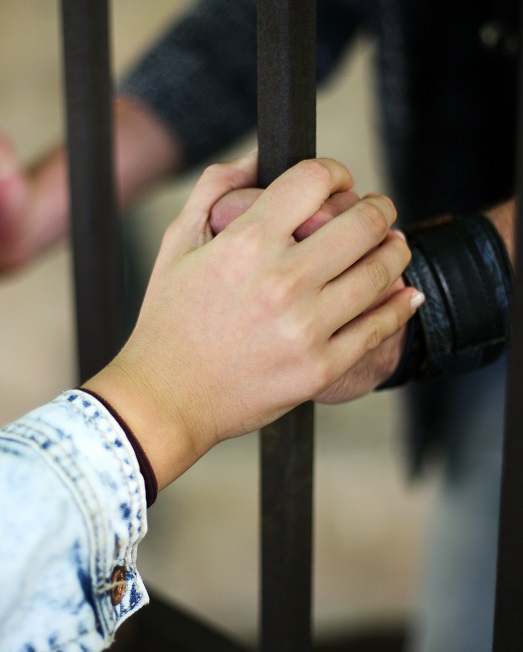 Holding hands through prison bars