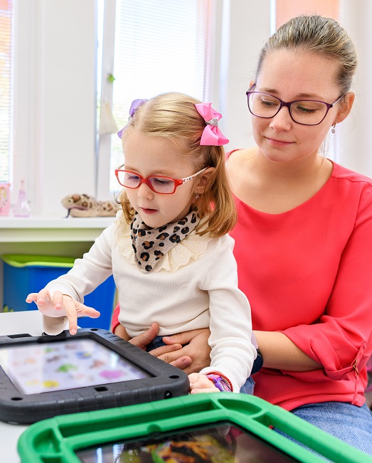 Child on iPad with teacher