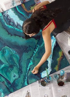 Taneal painting a large canvas invoking the ocean