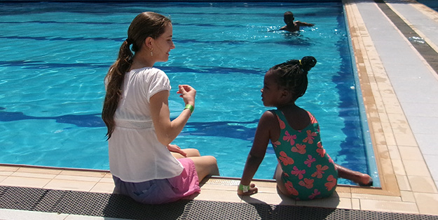 Kristen and child at pool in Uganda.
